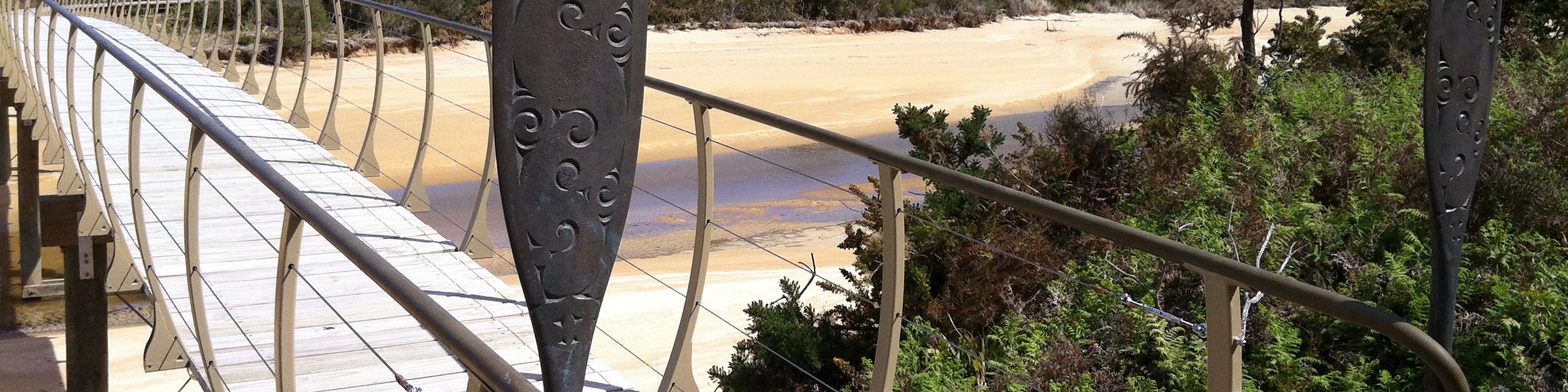 A carved timber boardwalk leading down to the beach