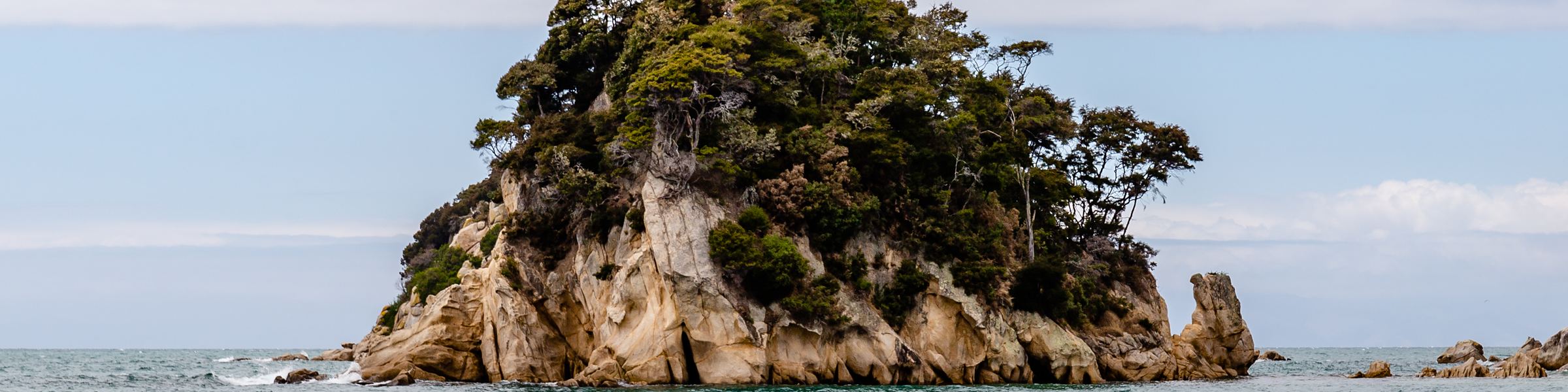 A bush-topped rocky islet just off Little Kaiteriteri Beach
